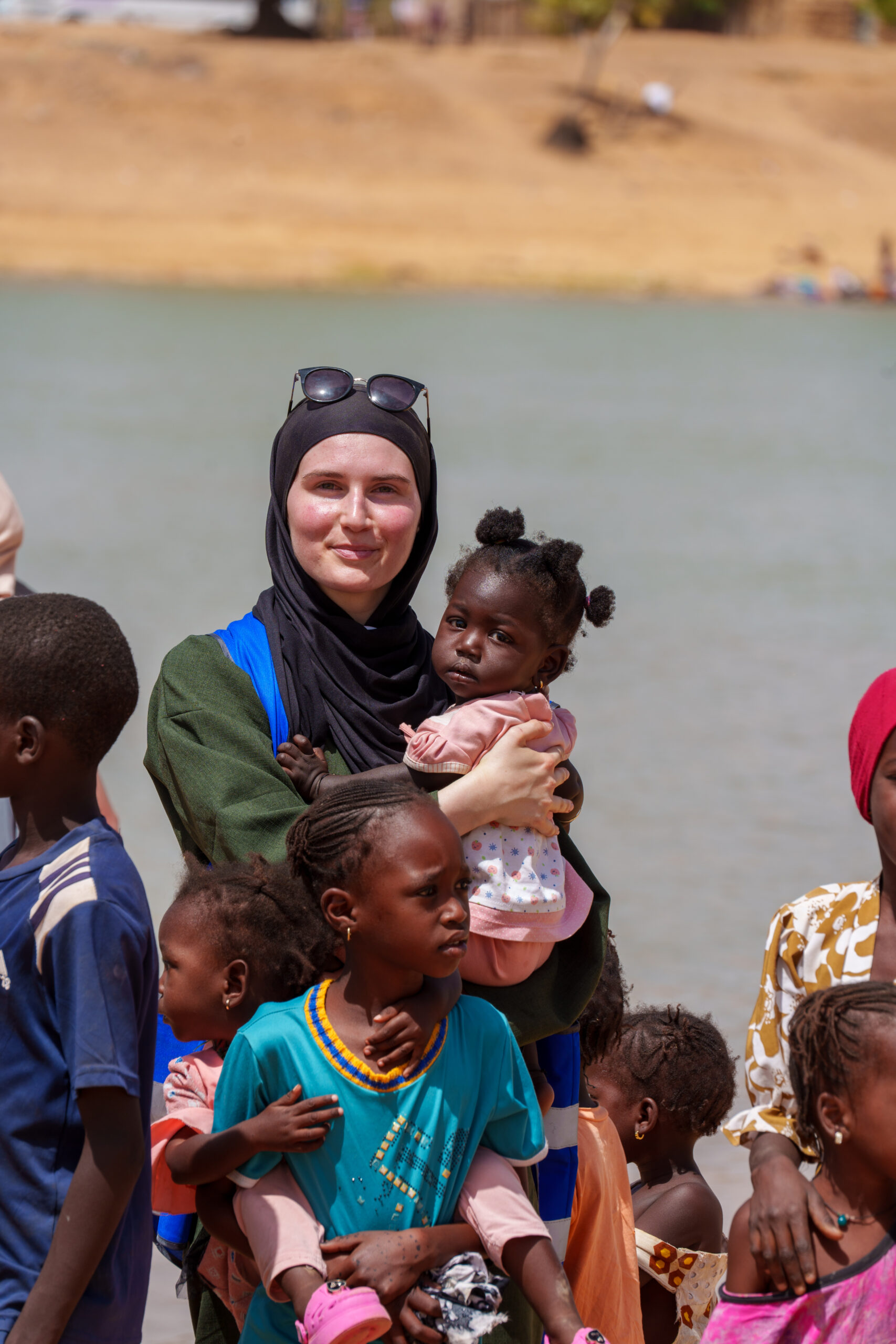 Une bénévole de Dunya Charity porte une petite fille lors d'une mission